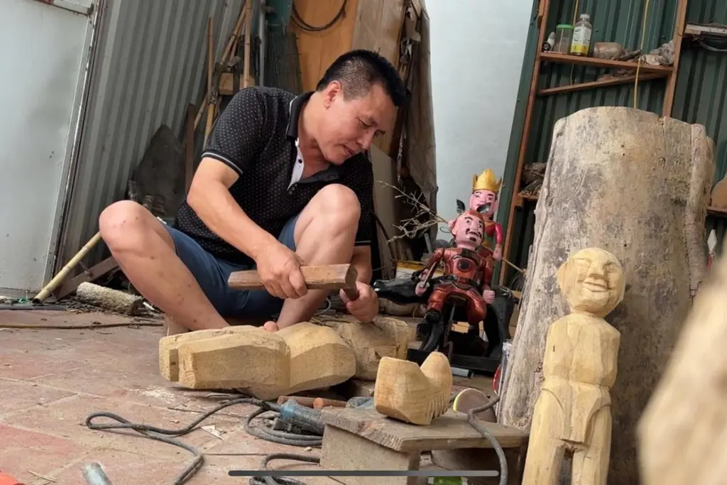 Nghệ nhân Nguyễn Văn Phi miệt mài với từng đường đục, nét khắc trên thân gỗ