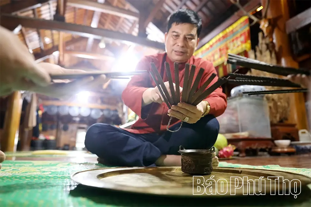 Nghệ nhân Bùi Văn Minh hướng dẫn con cháu cách xem lịch Khao Roi