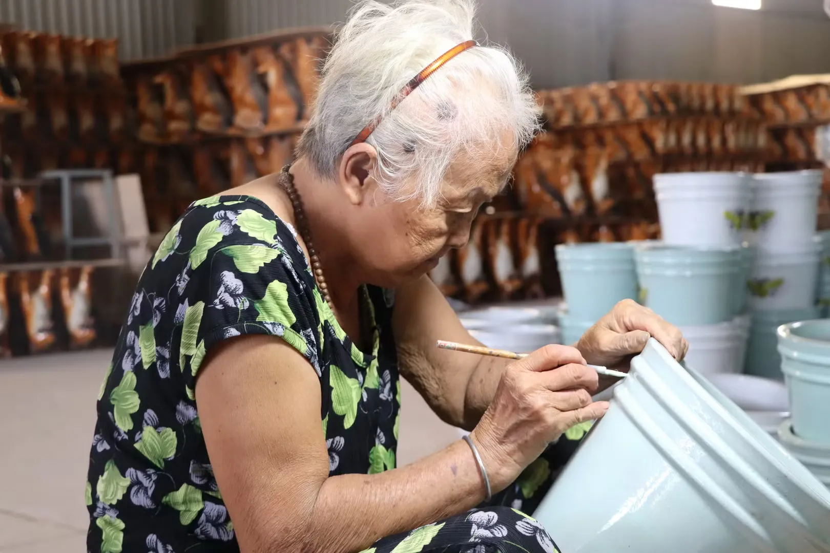 Một người thợ cao tuổi khắc hoa văn lên sản phẩm gốm Biên Hòa