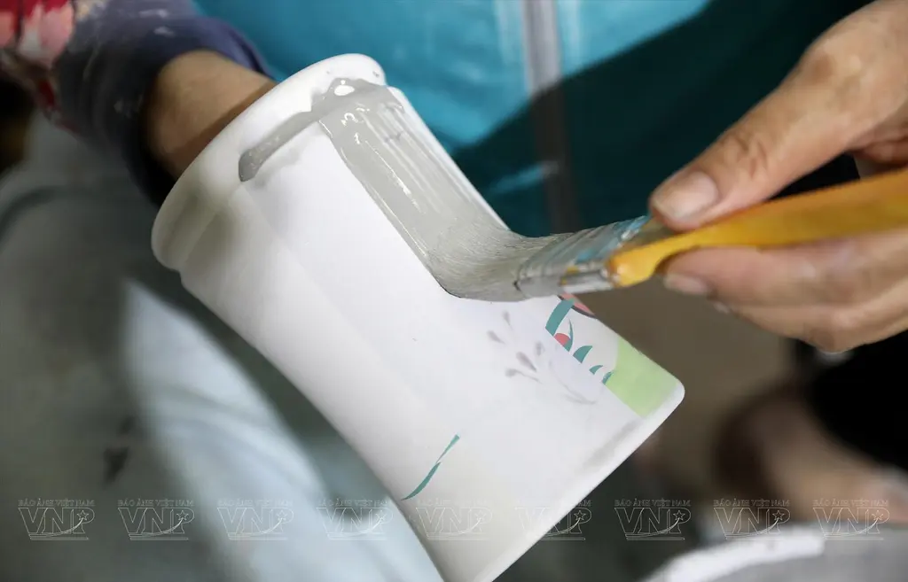 Công đoạn quét sơn lên sản phẩm gốm để giúp sản phẩm sau khi hoàn thành sẽ đều màu hơn.