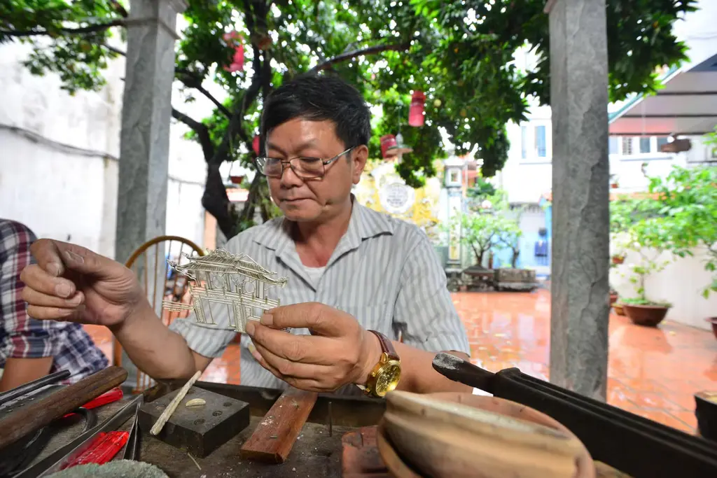 Hình ảnh nghệ nhân Quách Văn Hiểu đang chế tác bạc