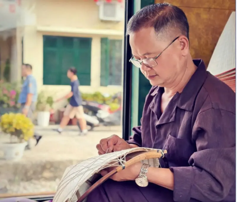 Nghệ nhân Lê Văn Tuy khâu nón lá