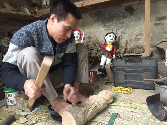 Nghệ nhân Nguyễn Văn Phi đục đẽo tạo dáng cho con rối