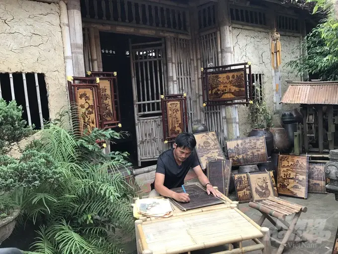 Nghệ nhân làng nghề tre Xuân Lai Nguyễn Văn Kỷ đang chế tác tranh tre