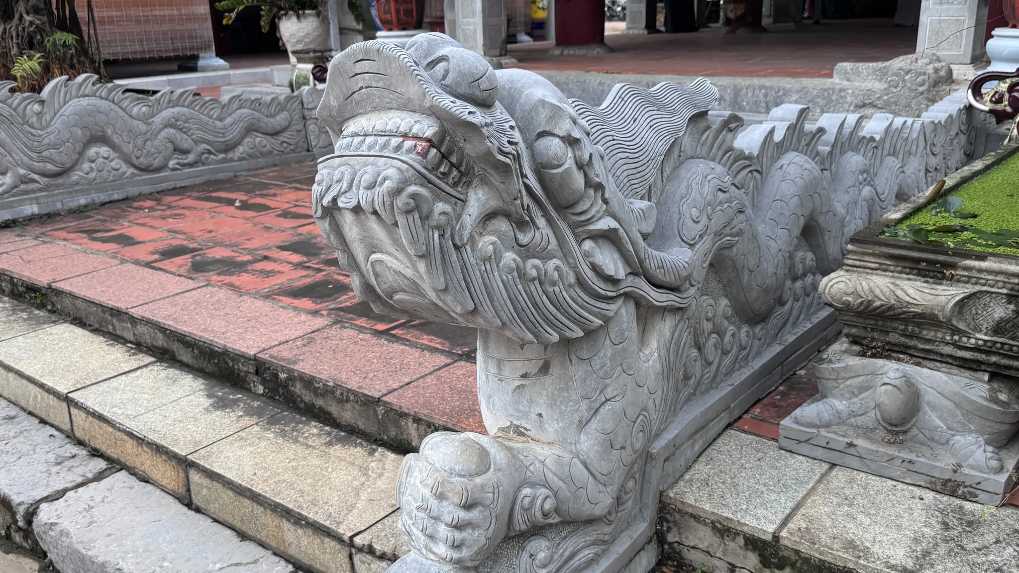 Đặc tả chi tiết đầu rồng đá bên lối vào phương đình đình Kiều Mai