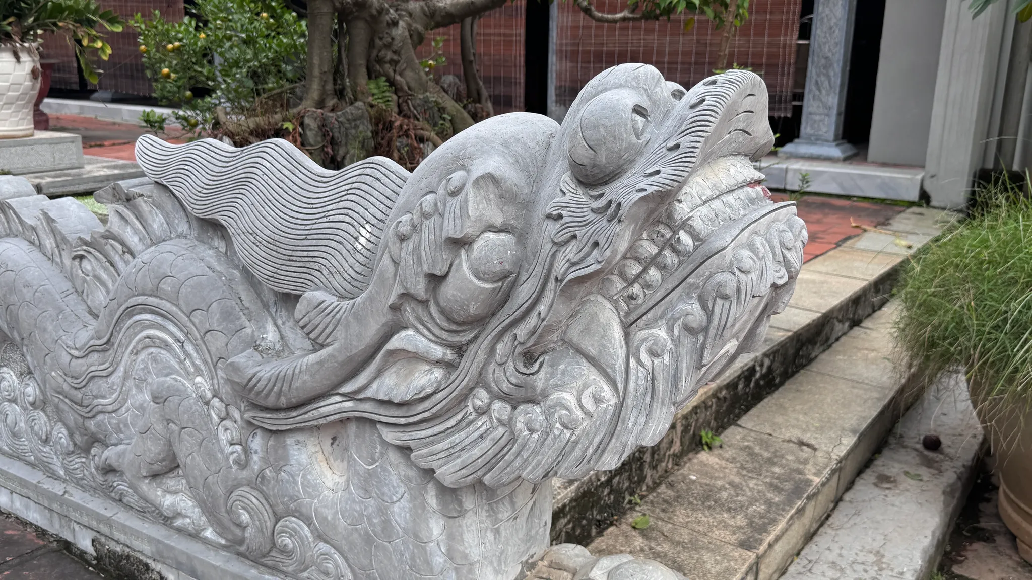 Đặc tả chi tiết đầu rồng đá bên lối vào phương đình đình Kiều Mai