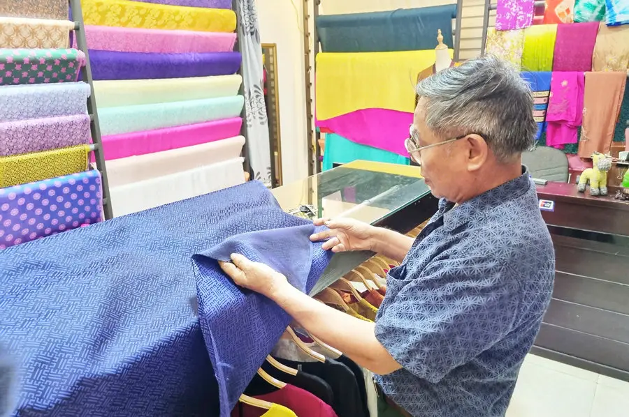Nghệ nhân Phạm Khắc Hà kiểm tra chất lượng lụa