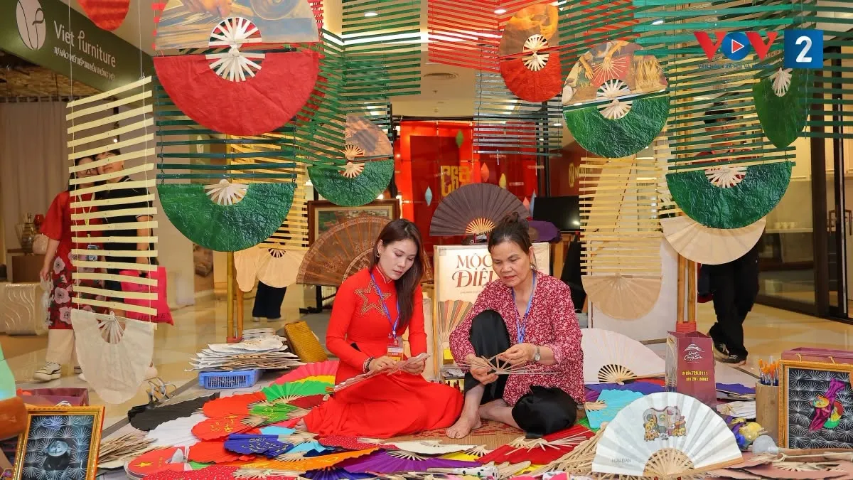 Nghệ nhân Nguyễn Thị Tuấn (bên phải) hướng dẫn mọi người cách làm quạt