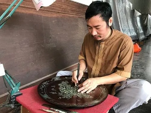 Nghệ nhân Nguyễn Đình Vinh đang say sưa sáng tác