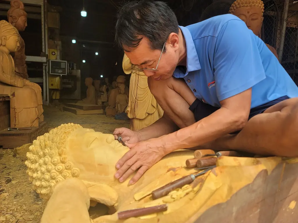 Nghệ nhân Nguyễn Trí Dũng đang tỉ mỉ tạo hình hoàn thiện những công đoạn cuối cùng của một pho tượng