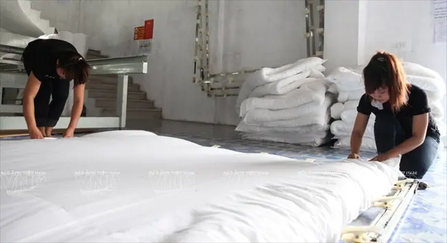 Công đoạn làm căng chăn bông trước khi đưa lên máy khâu
