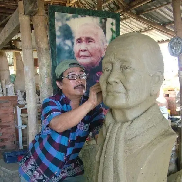 Nghệ nhân Lê Đức Hạ đang tạc tượng trong xưởng gốm của mình