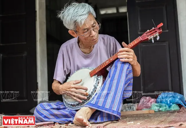Nghệ nhân Đào Soạn chỉnh âm cho một chiếc đàn mới.