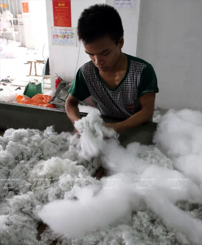 Công đoạn đầu tiên của nghề bật bông là đưa nguyên liệu vải vào máy để nghiền bông