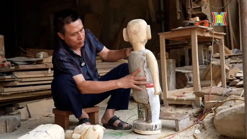 Nghệ nhân Nguyễn Văn Phi đang lắp ghép máy hoạt động cho con rối