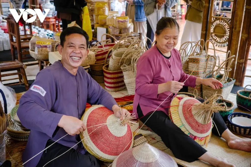 Nghệ nhân Đỗ Văn Tấn (bên trái) rạng rỡ bên sản phẩm từ cói của mình