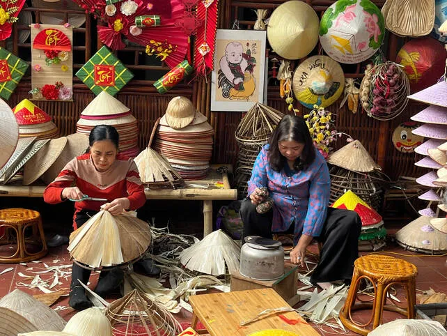 Nghệ nhân Tạ Thu Hương (bên phải) thực hiện các công đoạn làm nón lá