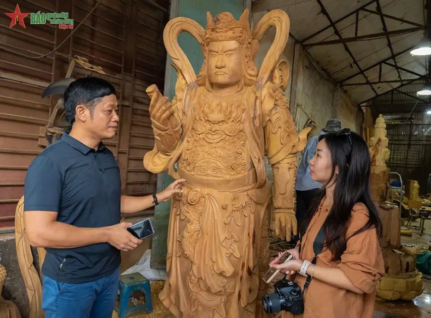 Nghệ nhân Hà Nội Nguyễn Viết Lợi (trái) chia sẻ với phóng viên