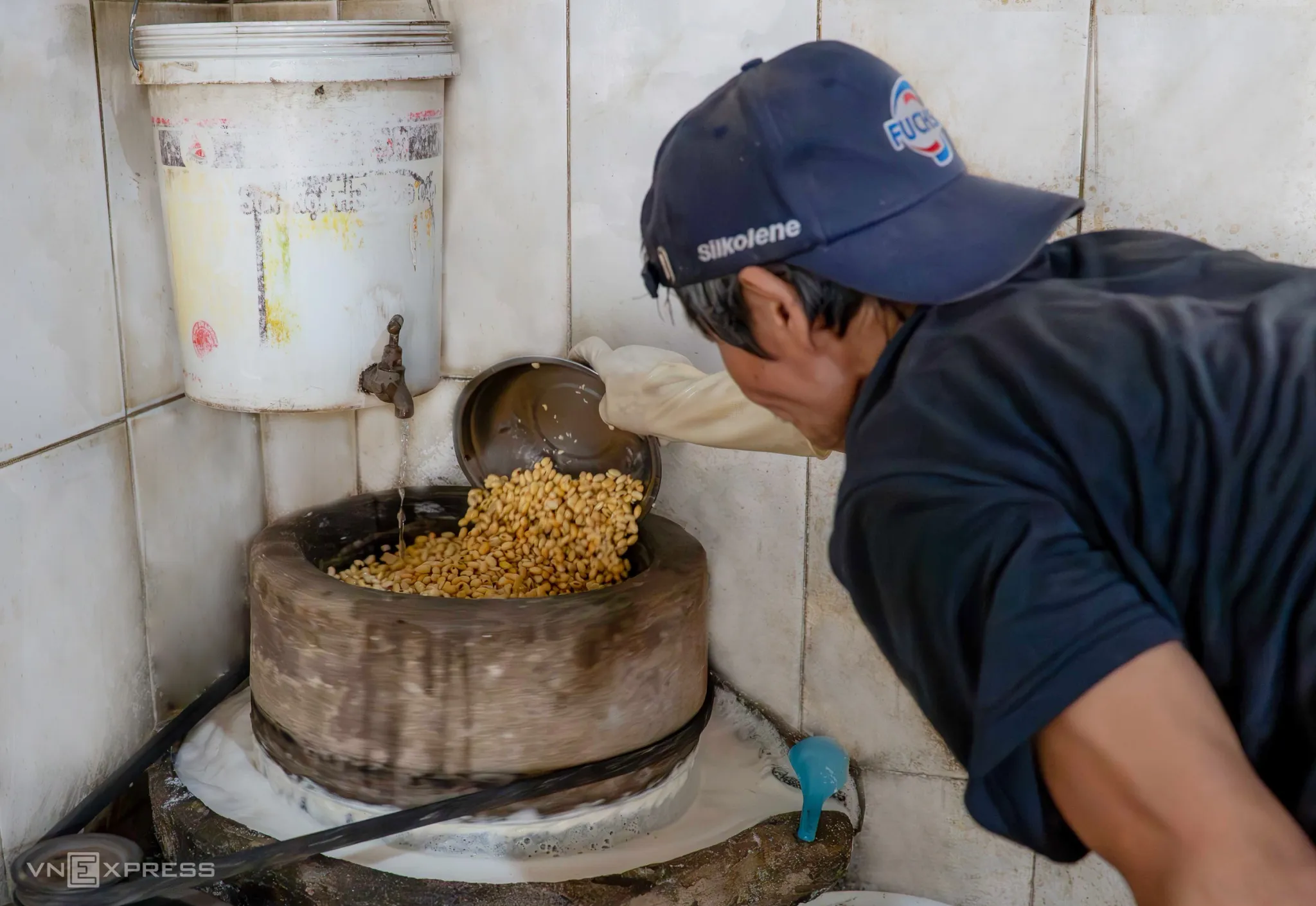 Hạt đậu được đổ lên cối xay, vừa xay vừa điều chỉnh lượng nước cho phù hợ