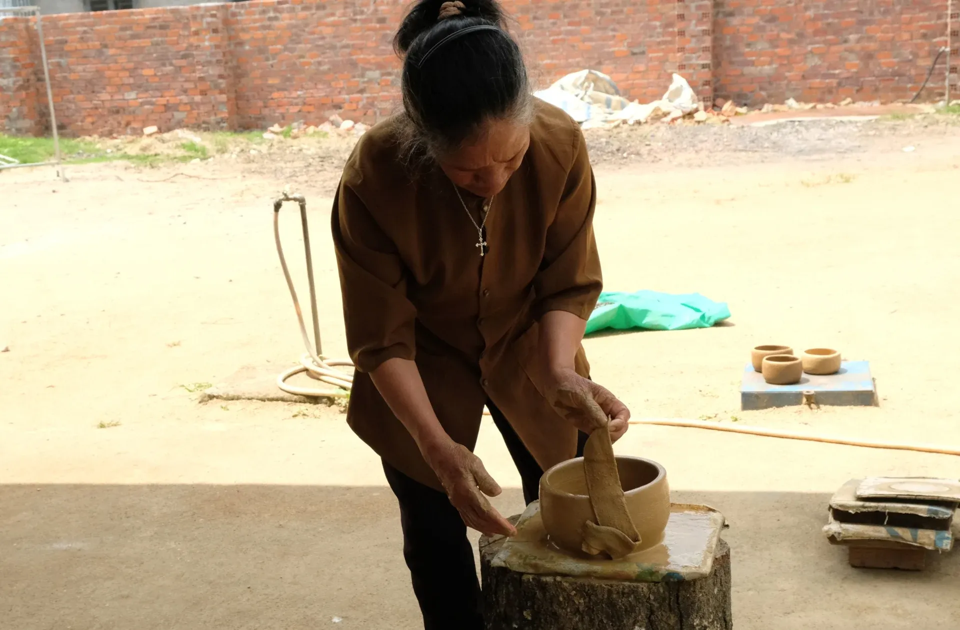 Nghệ nhân Ma Ly đang hoàn thiện công đoạn cuối dùng tạo hình sản phẩm gốm Churu