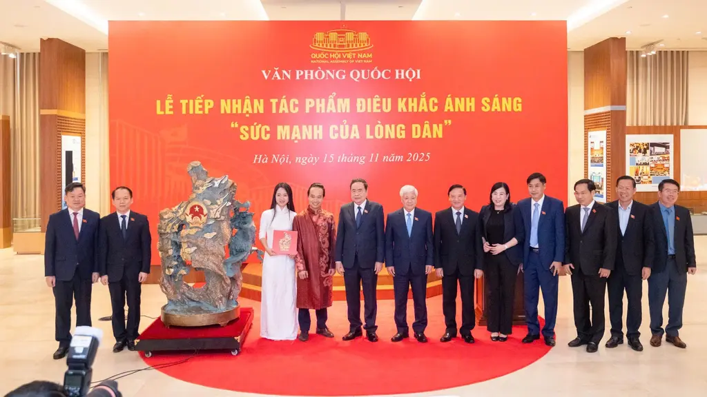 Nghệ nhân Bùi Văn Tự (áo đỏ) trao tặng Quốc hội tác phẩm Sức mạnh của lòng dân