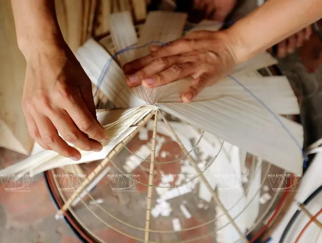 Công đoạn cho lá vào vành để tạo thành chiếc nón của người thợ làng Phú Châu
