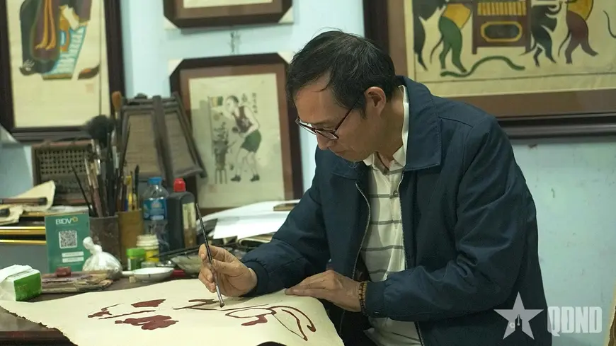 Nghệ nhân Ưu tú Nguyễn Hữu Quả chăm chút từng nét màu trên giấy điệp tranh Đông Hồ