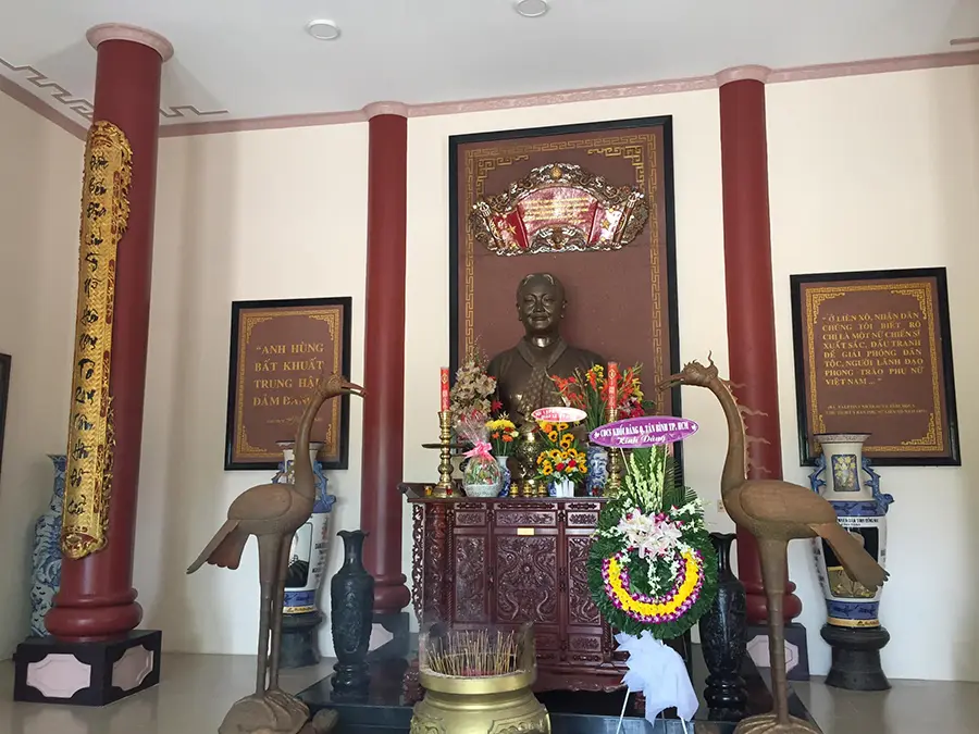 Bàn thờ đặt tượng Nguyễn Thị Định bằng đồng trong trang phục áo bà ba và khăn rằn quấn quanh cổ