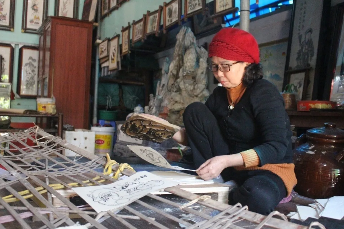 Nghệ nhân Nguyễn Thị Oanh say sưa bên giấy gió, ván in tranh.