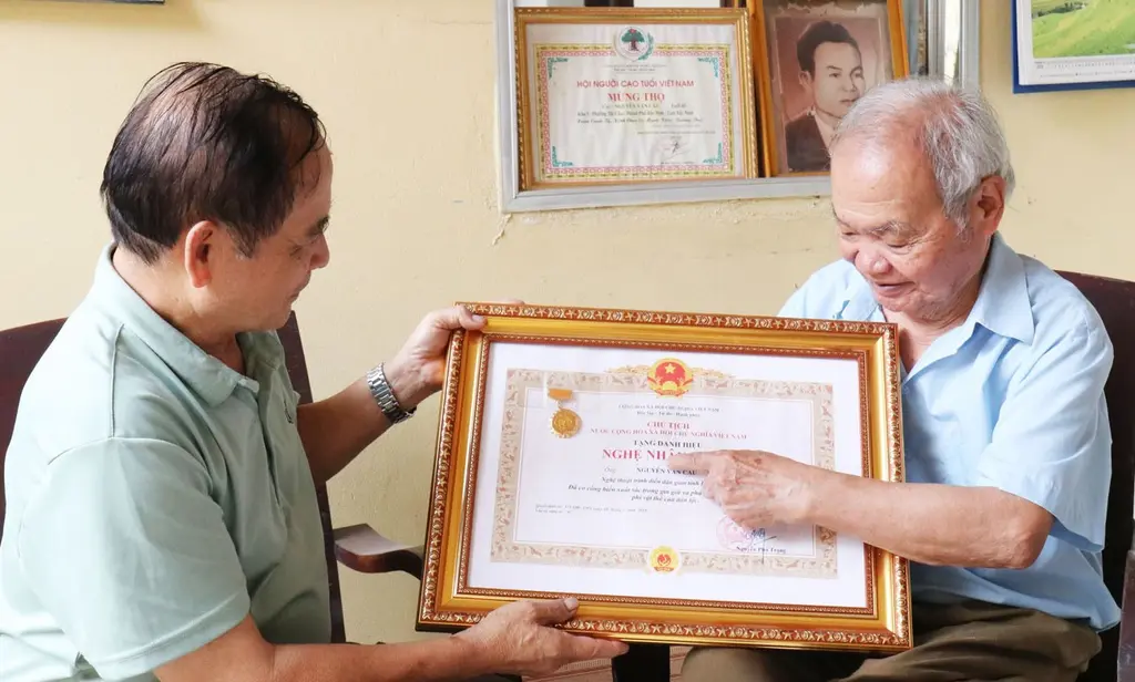 Nghệ nhân Nhân dân Nguyễn Văn Cầu (bên phải) tự hào về Bằng công nhận Nghệ nhân Ưu tú do Chủ tịch nước công nhận