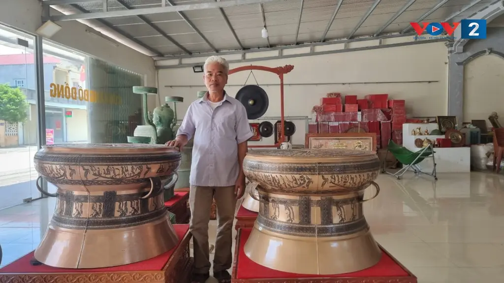 Nghệ nhân Ưu tú Nguyễn Bá Châu bên cặp trống đồng mới đúc