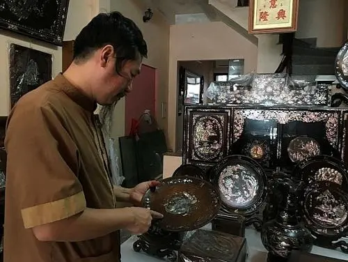 Nghệ nhân Nguyễn Đình Vinh đang giới thiệu những sản phẩm khảm trai do mình tạo ra